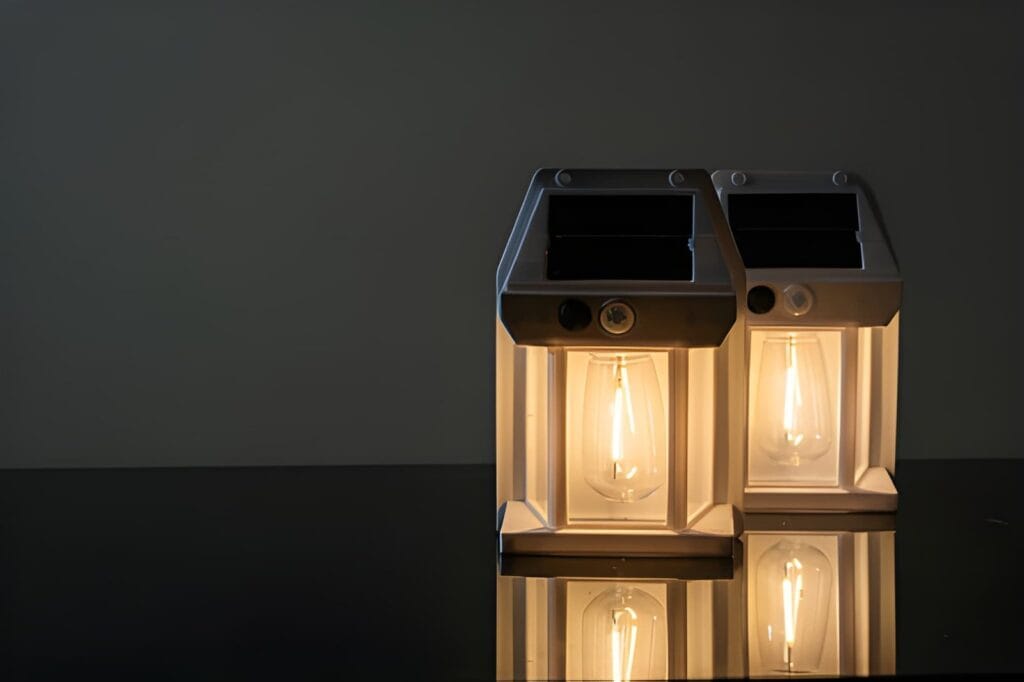Three glowing battery lanterns on a dark reflective surface, providing warm emergency lighting for a power outage preparedness guide.