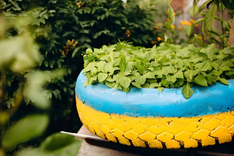 Colorful upcycled tire planter filled with green plants for creative Tire Upcycling Garden Projects.